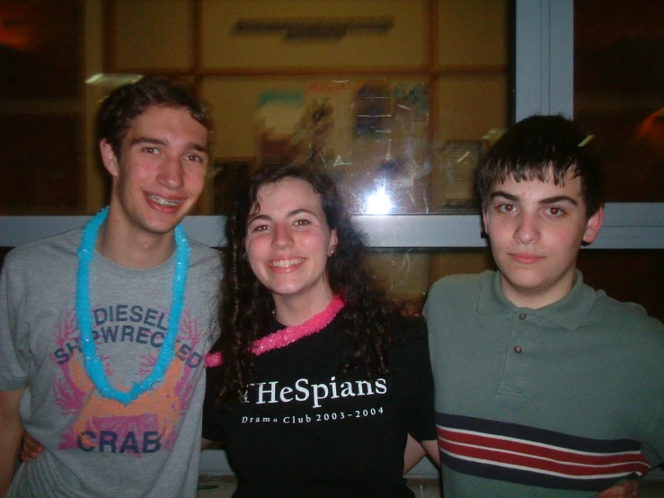 three young people are standing with each other smiling