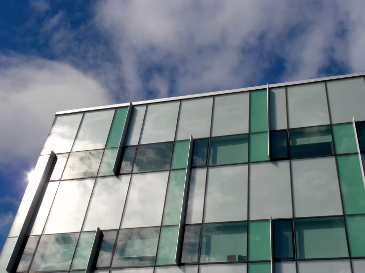 the clouds are reflected in the windows of a modern building