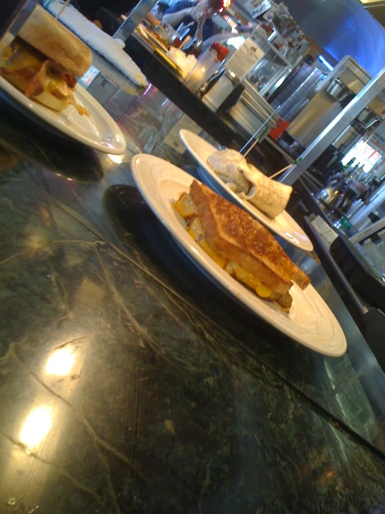 two plates filled with sandwiches on a counter