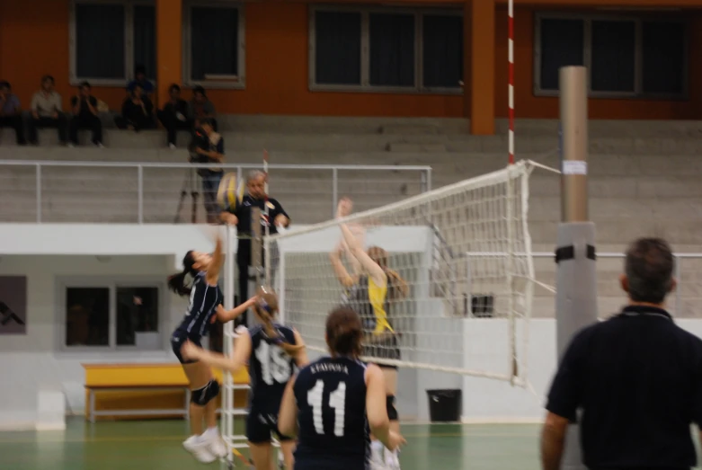 some people are playing volleyball in a gym