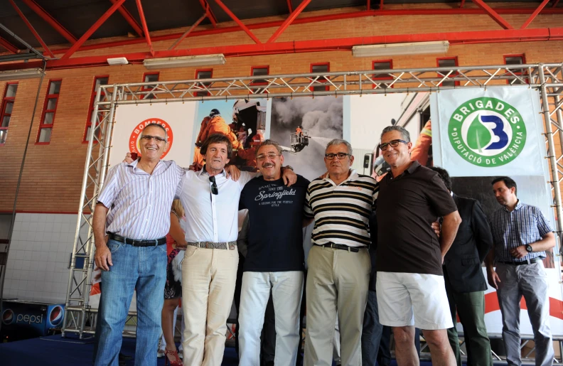 four men posing for the camera during an event