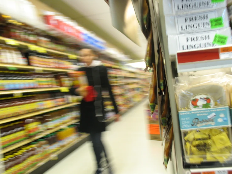 a blurry s of a man walking through the aisle of a store