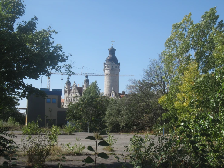 an old building has some trees and bushes near it