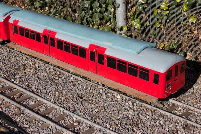 the red passenger train is passing by on the track