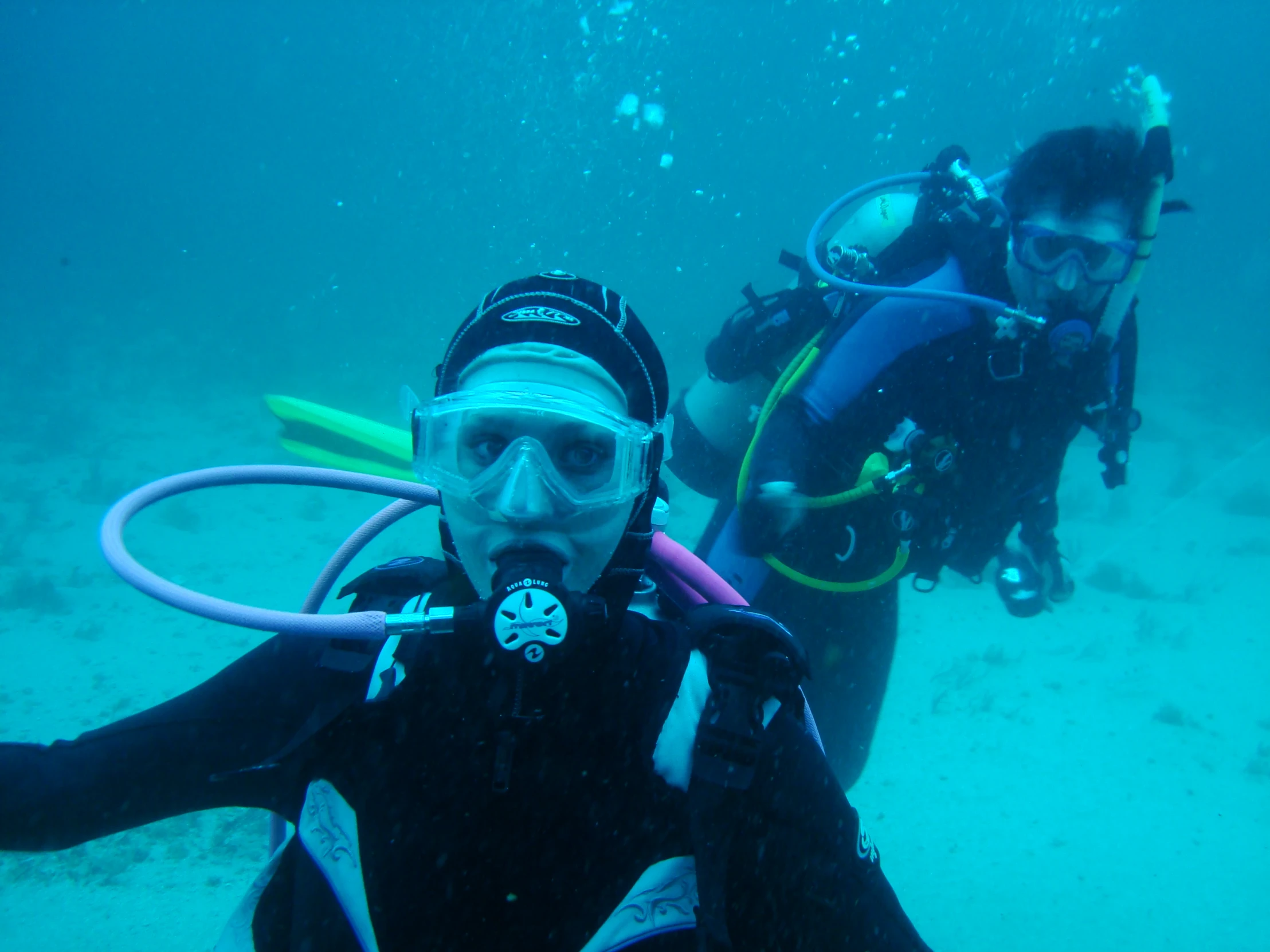 scuba enthusiasts pose in the water with their equipment