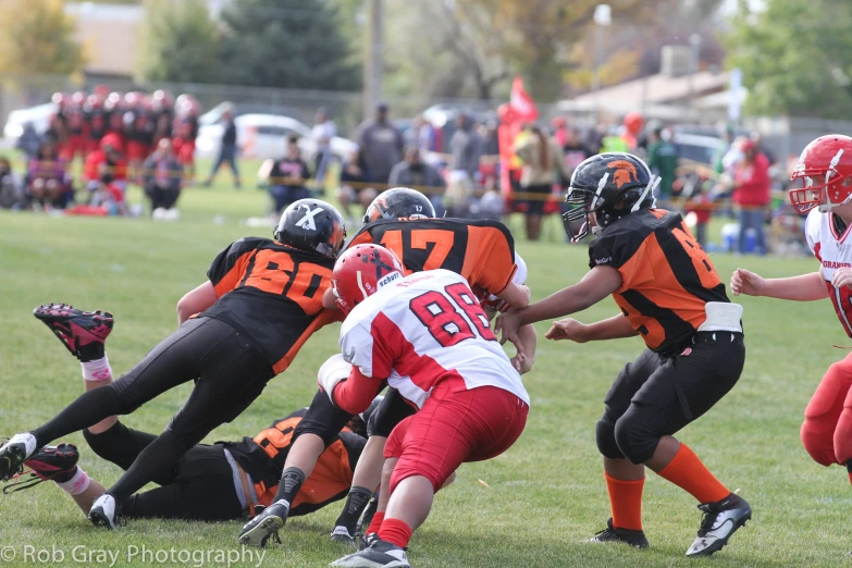 the players in a football game are grabbing each other with their hands