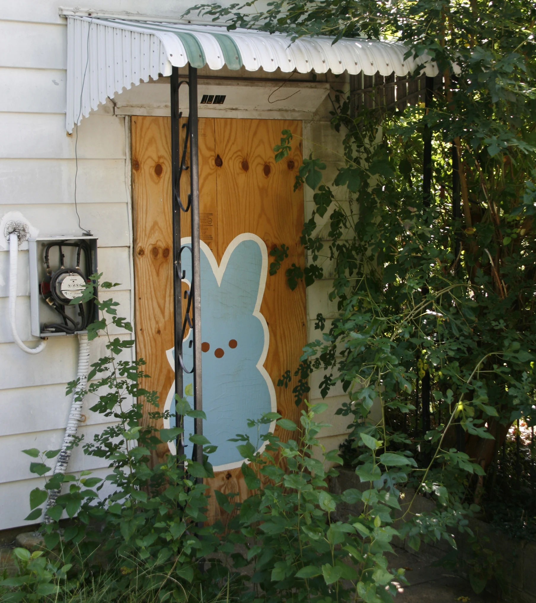 a door in the woods with an easter rabbit painted on it