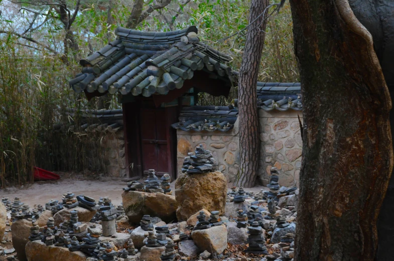 a stone wall with mushrooms on top and rock garden in front of it