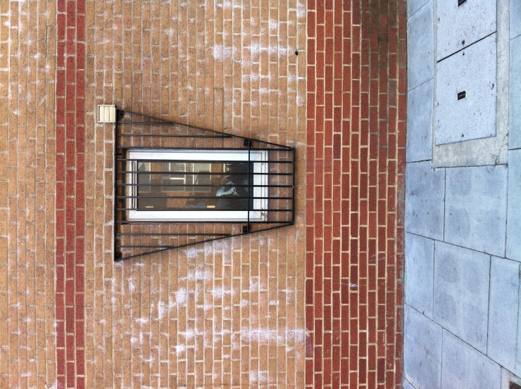 a brick building with a large window and grill