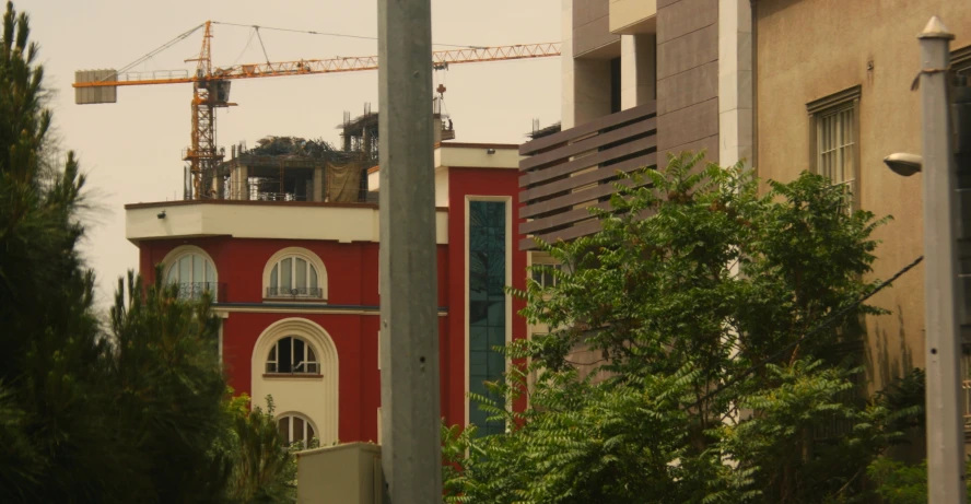 an apartment building under construction with a tower crane