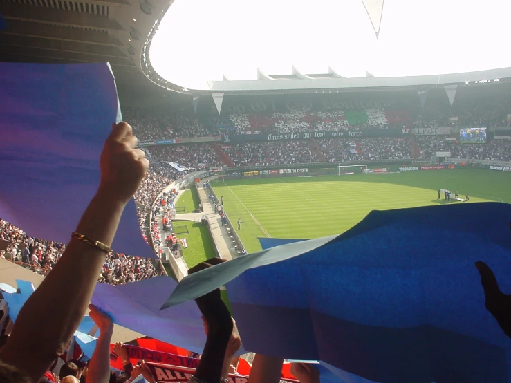 a group of people holding up a blue piece of paper with a white umbrella