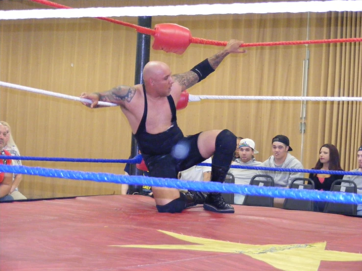 a wrestling match in action, with a referee on the ground