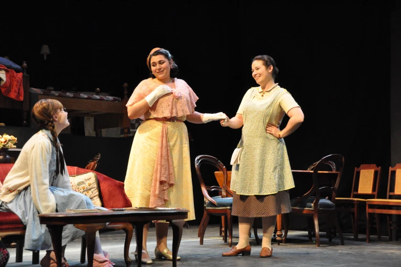 two women shaking hands at a stage setting