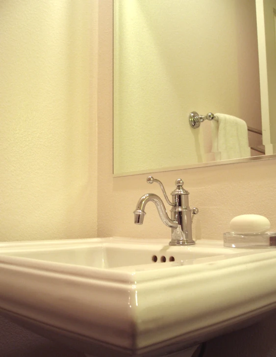 this bathroom has a sink, mirror and soap dispenser