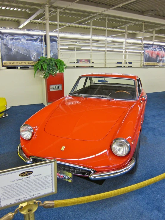 an orange sports car on display in a building