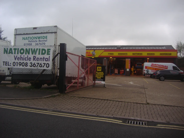 a vehicle wash business with trucks behind the fence