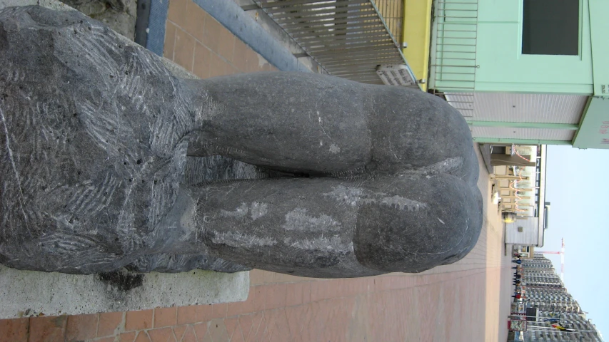 large statue of a seated animal sits in the street