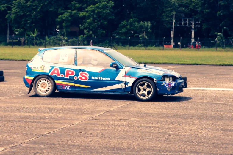 an automobile that is on the ground with trees behind it