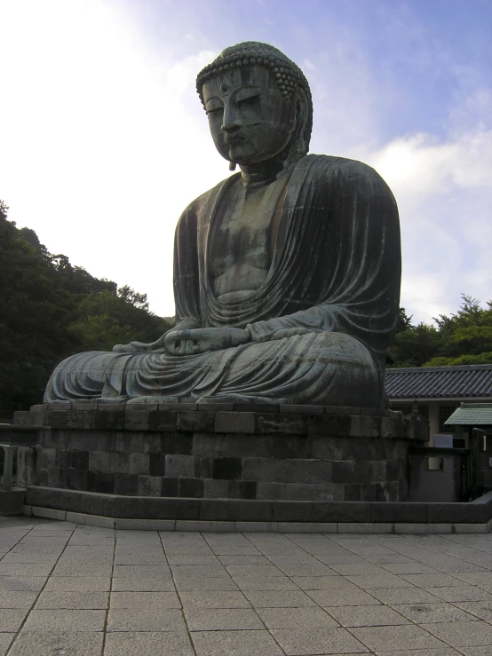 a statue of a seated buddha on a brick wall