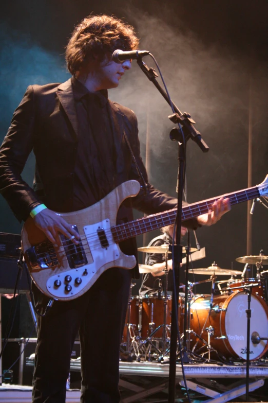 a man is playing his bass guitar on stage