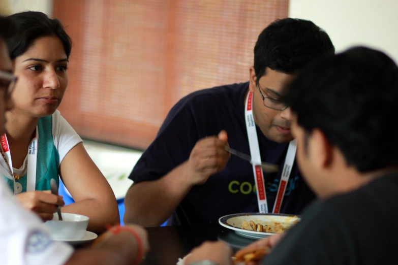 some people sitting and eating food at a table