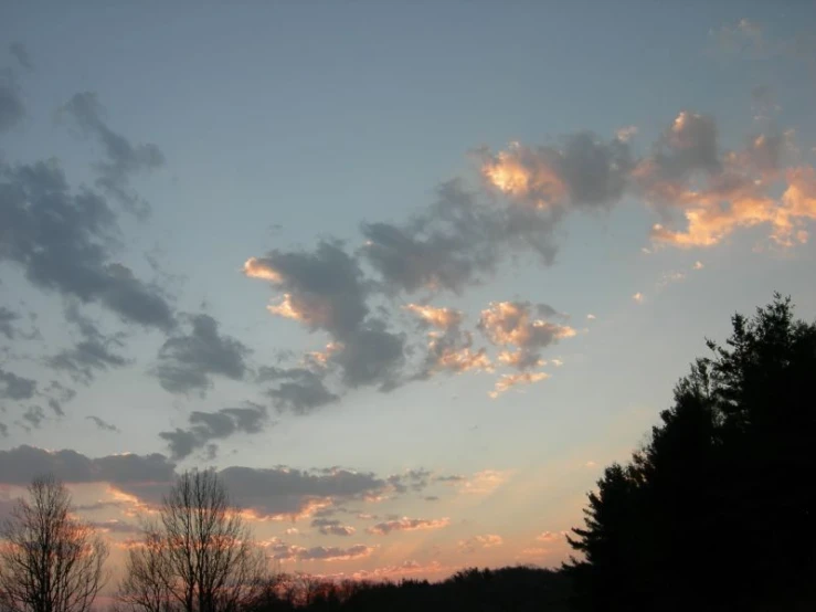 clouds over a lake and trees at sunset