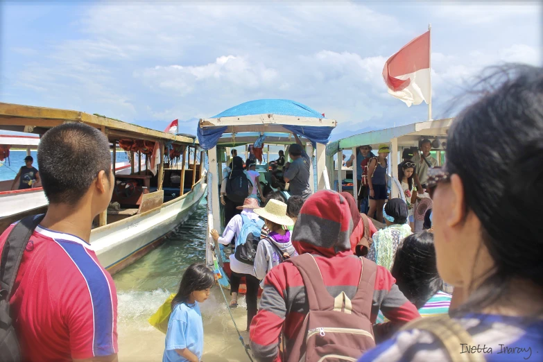 tourists disembark from a boat on the water