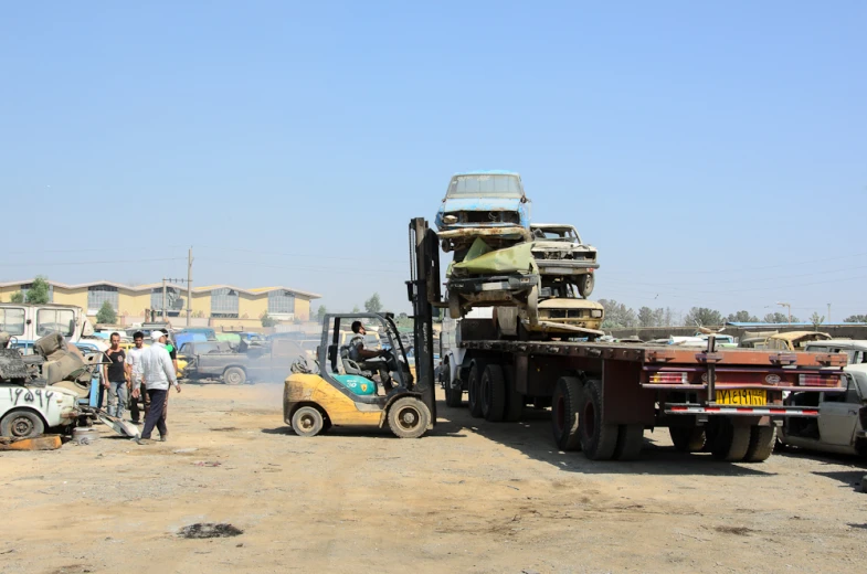 a man standing next to several trucks near a building