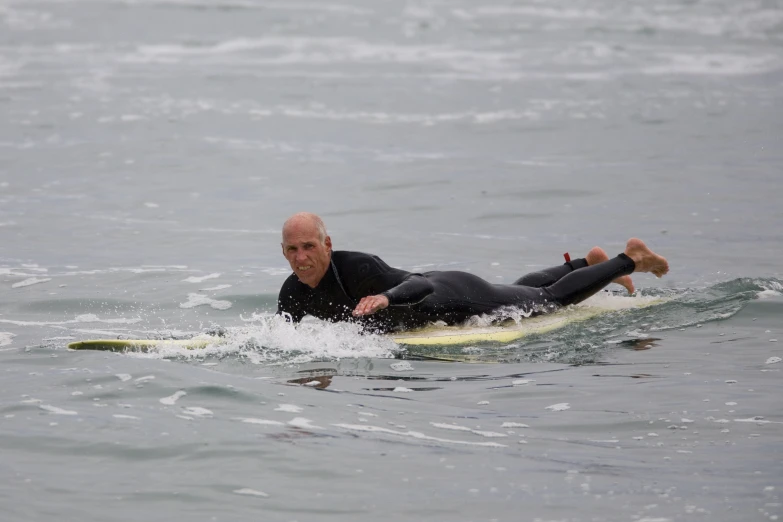 a person lying on a surfboard in the water