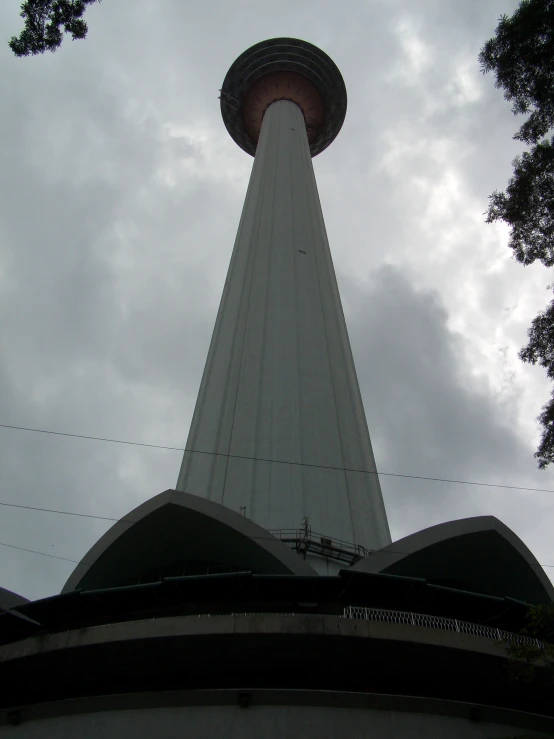 looking up at the side of the tower and a cloudy sky