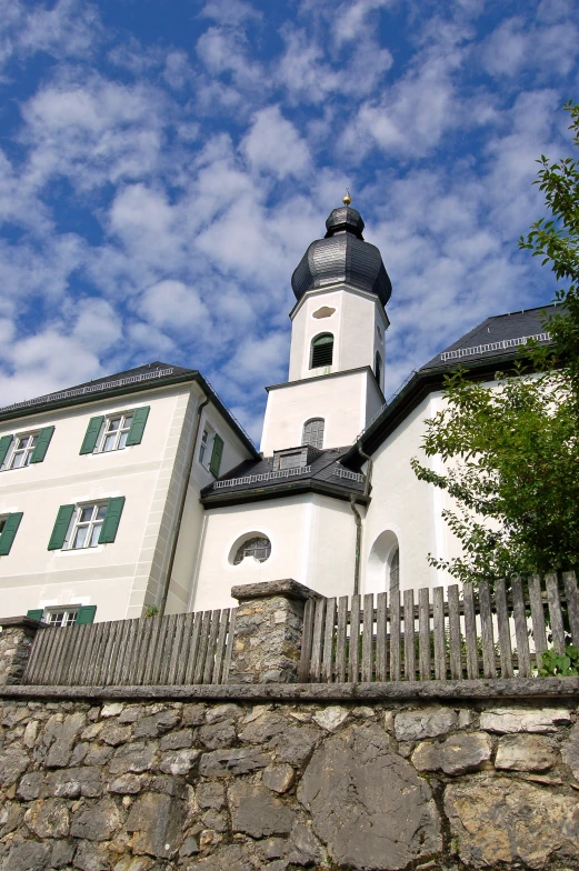 the old white building has a tall steeple