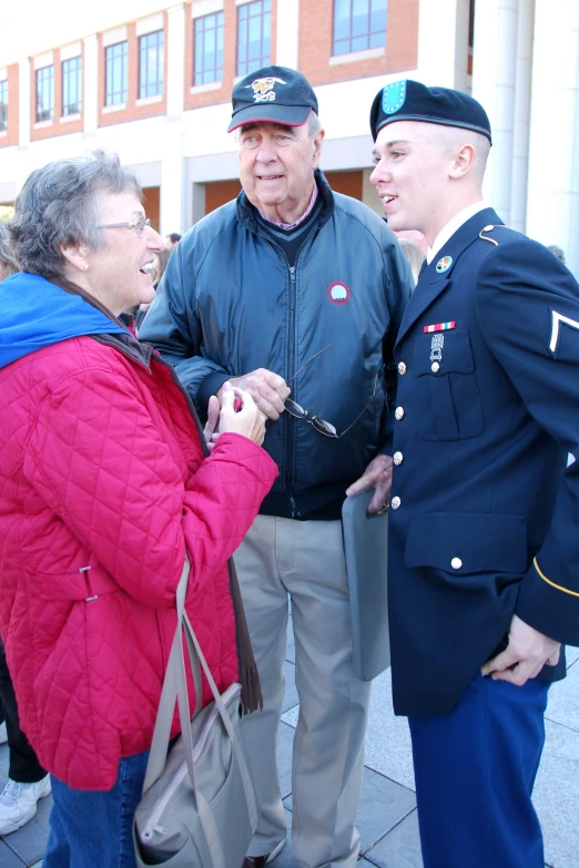 two men shaking hands over a woman with an older man in uniform