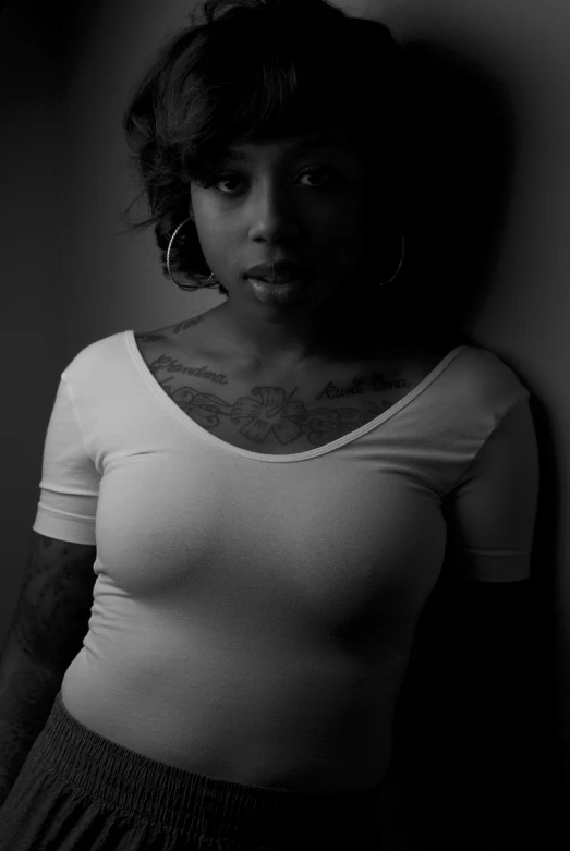 a black and white po of a woman with a tattoos on her chest