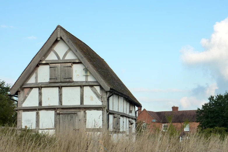 a large white and brown building in the middle of a grass field