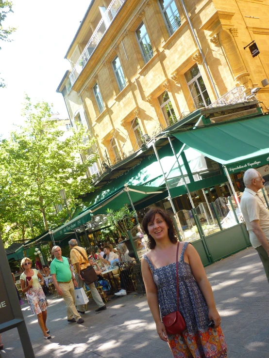 a lady smiles while standing outside of an old building