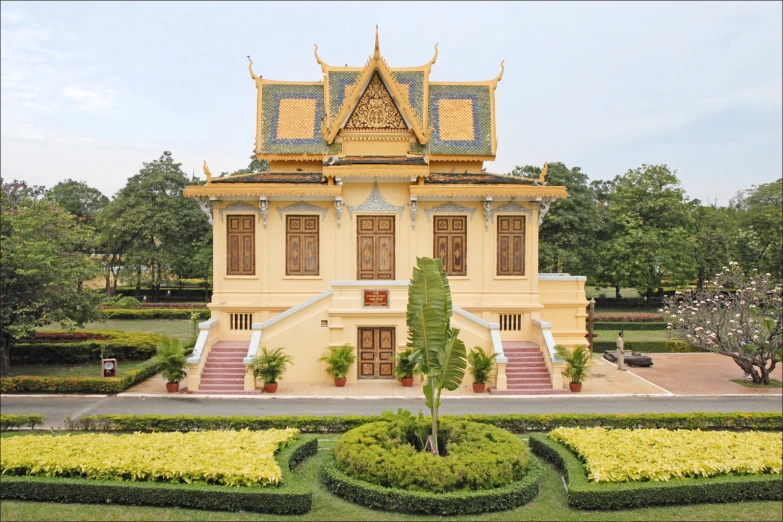 a very big pretty yellow building in a park