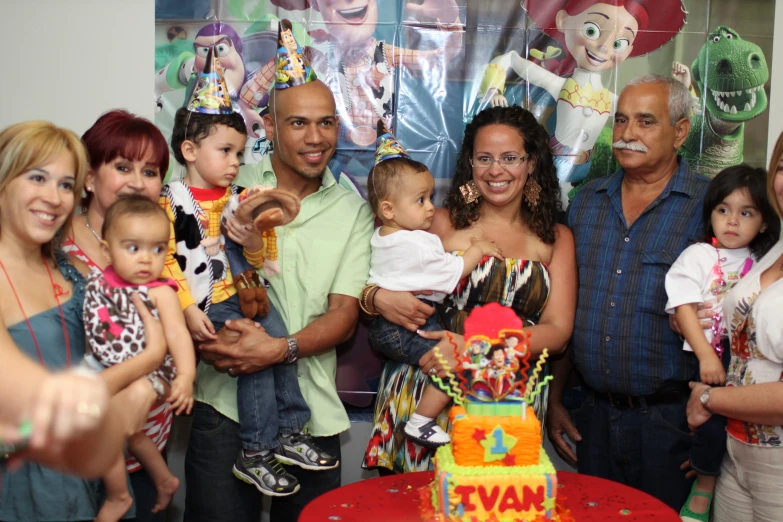 group of adults and children near a birthday cake