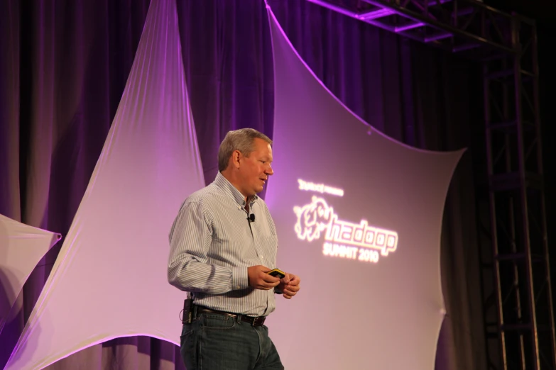 a man standing in front of a purple backdrop