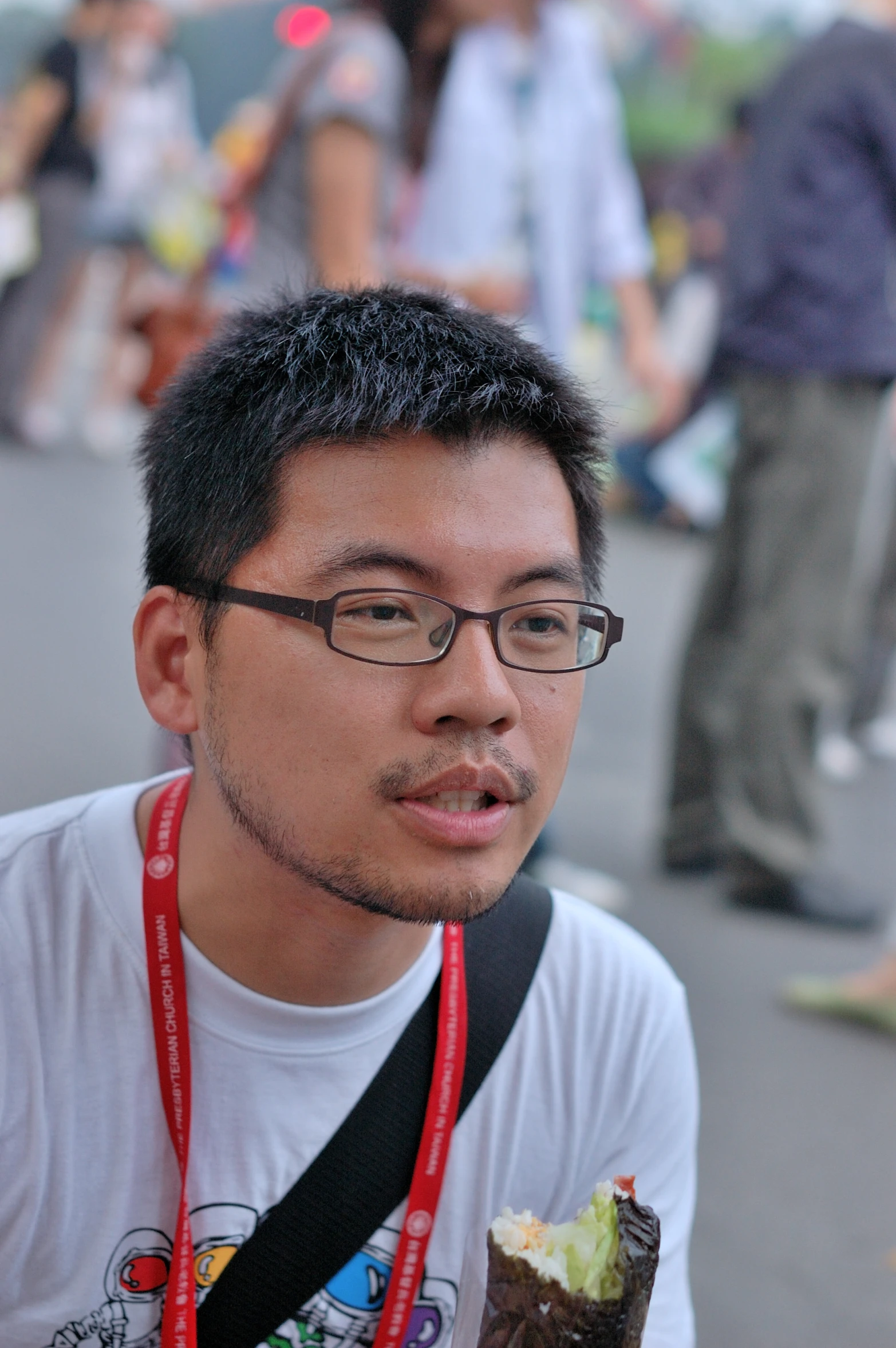 a young man taking a selfie while holding onto a camera strap