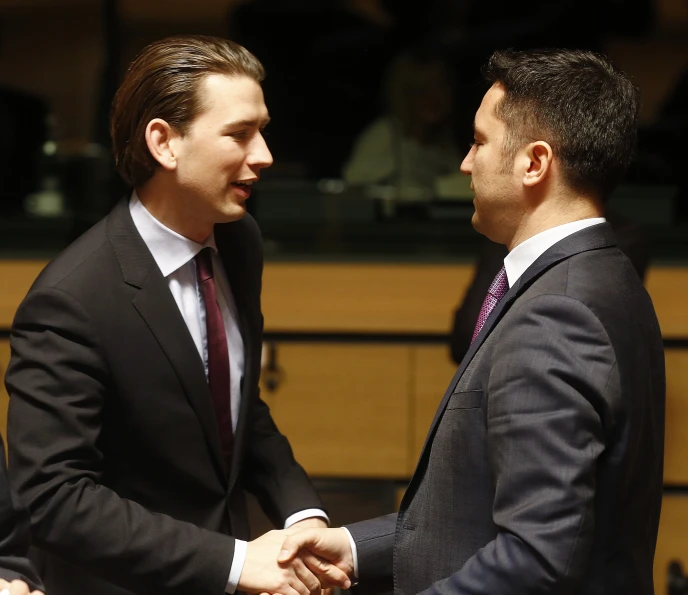 two men are shaking hands in front of an audience