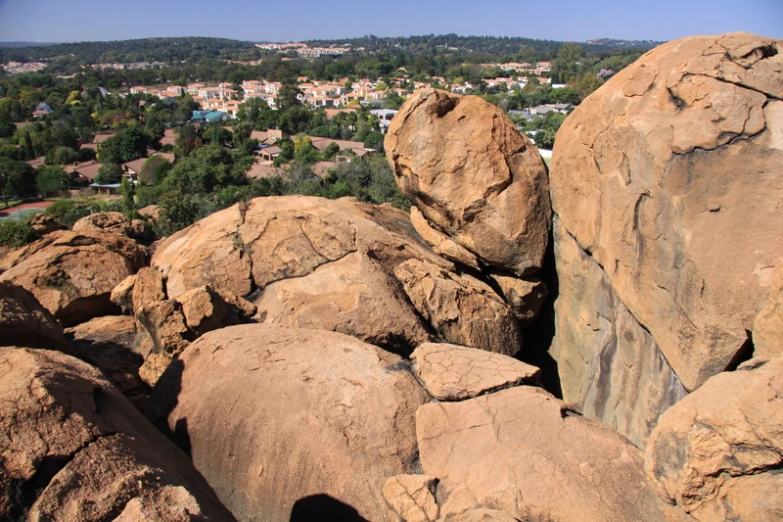 some big rocks in the dirt and one of them has trees