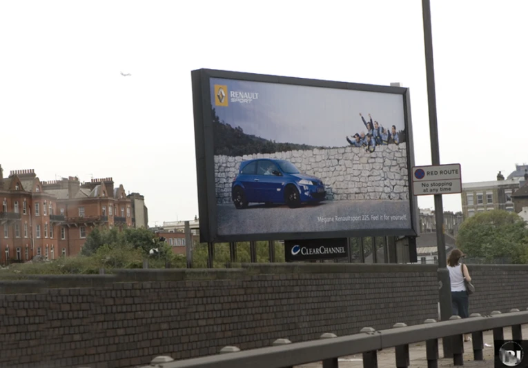 a billboard is next to a wall and some people