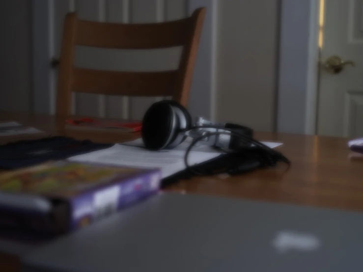 camera sitting on the table next to an opened notebook