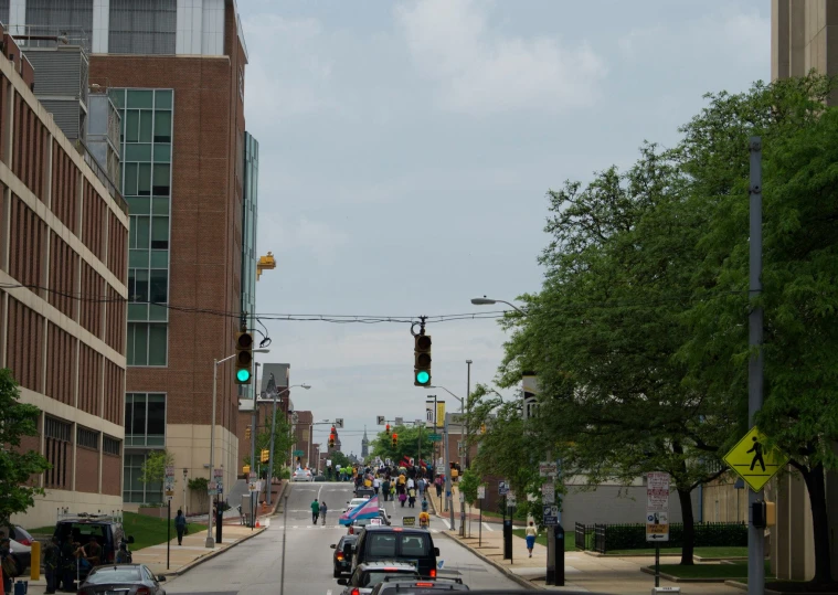 cars and pedestrians traveling down a street lined with buildings