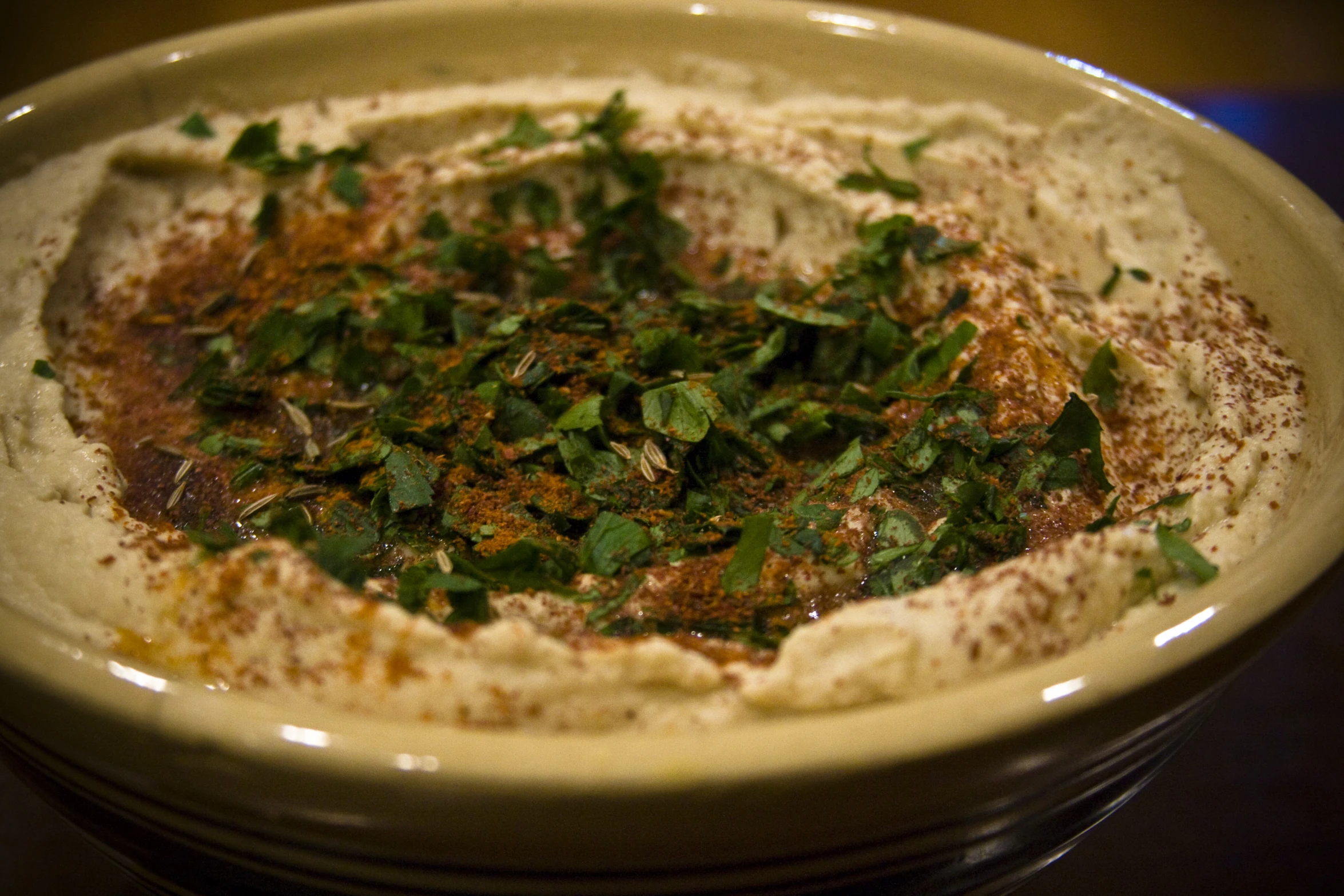 a bowl filled with a brown substance and chopped parsley