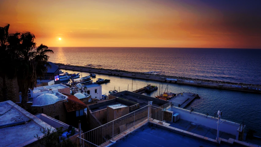 the sun setting on a city with buildings and water