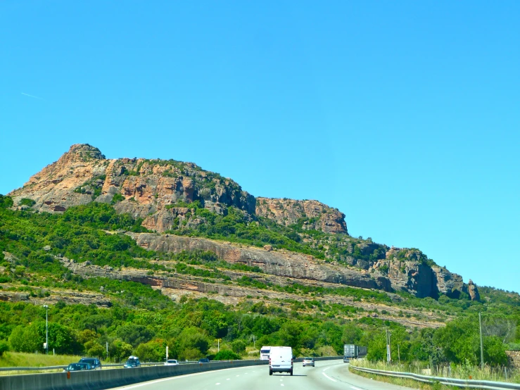 the view of a road with a mountain in the background