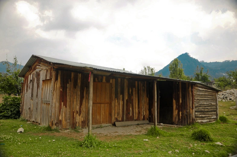 an old rustic barn with a covered up wooden door