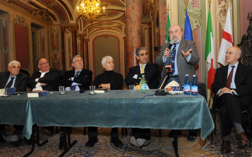 the group of businessmen is talking while seated at the table