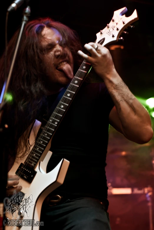 a man with long hair playing a guitar